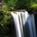 Menschen beobachten einen Wasserfall